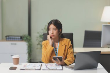 Modern ofis odasında dizüstü bilgisayarla projesinde çalışan çekici genç bir iş kadını..
