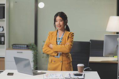 Modern ofis odasında dizüstü bilgisayarla projesinde çalışan çekici genç bir iş kadını..