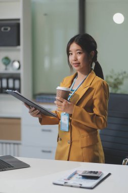 Modern ofis odasında dizüstü bilgisayarla projesinde çalışan çekici genç bir iş kadını..