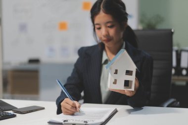 Emlakçılar, konut modellerini müşterilere ayrıntılı bir şekilde anlatma, evler ve satın alma kredileri hakkında bilgi verme ve sunma konularında açıklar. Gayrimenkul ticareti.