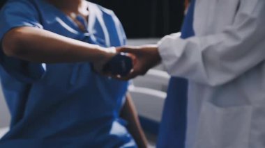 Üniformalı erkek doktorun el ele tutuşması.