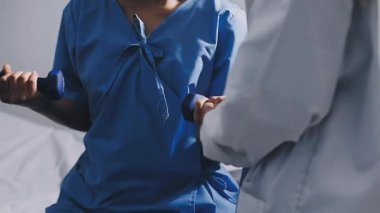 Doktor steteskopla el ele tutuşuyor, hastane koğuşunda.