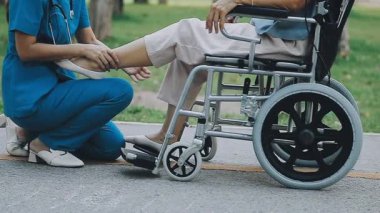 Bahçede tekerlekli sandalyesi olan genç bir kadın,