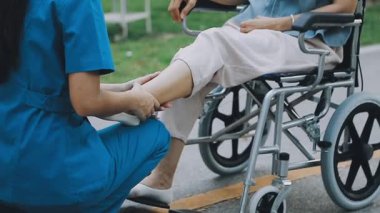 Tekerlekli sandalyeli Asyalı kadın hasta yerde oturuyor..