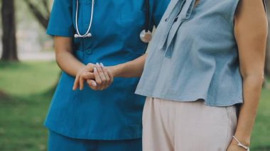 Doktor ve hemşire şehirde yürüyorlar, sağlık hizmeti kavramı, yaşlı bir kadının yardımı...