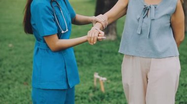 İki kadın doktor hastalarıyla el sıkışıyor.