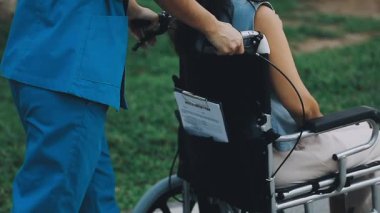 Parkta bebek arabası olan genç bir kadın.