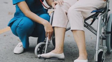 Tekerlekli sandalyedeki genç kadın ve hemşire