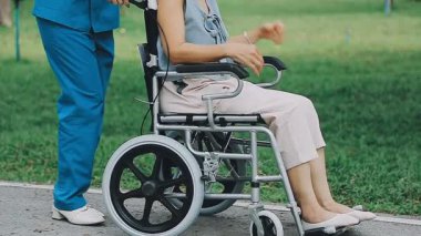 Tekerlekli sandalyedeki engelli kadın kocasıyla parkta.