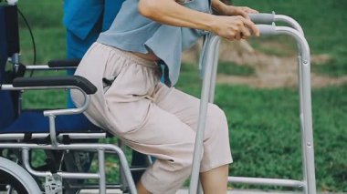 Parkta tekerlekli sandalyesi olan engelli bir kız. Koltuk değnekli bir kadın. Engelli kişi