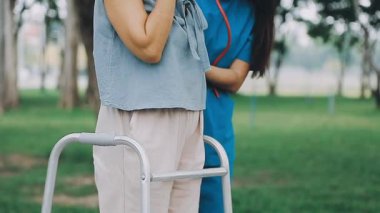 Parktaki kadın bastonuyla yürüyor.