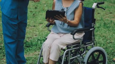 Hemşiresi ve tekerlekli sandalyesi olan genç bir kadın