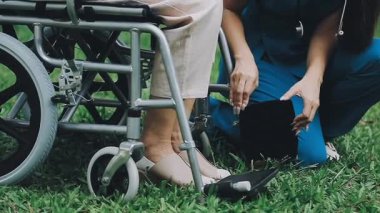 Parkta tekerlekli sandalyeli genç Asyalı kadın. sağlık hizmetleri