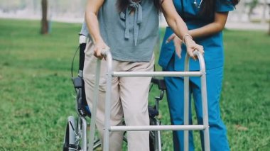 Kadın kocasıyla tekerlekli sandalyede yürüyor.