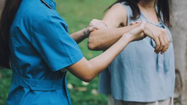 Genç kadın ve üniformalı genç doktor hastanede el ele tutuşuyorlar..