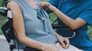 Tekerlekli sandalyede el ele tutuşan kadın