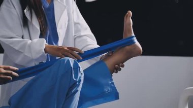 Mavi üniformalı doktorun hastanede tıbbi eldiven giydiği görüntüler.