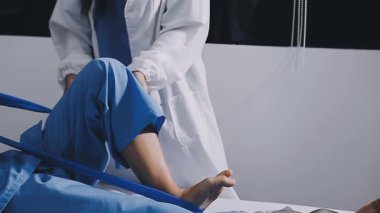 Hastanın bacağında şırınga olan bir doktor.