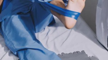 Mavi üniformalı doktor hastane odasındaki yatakta yatıyor..