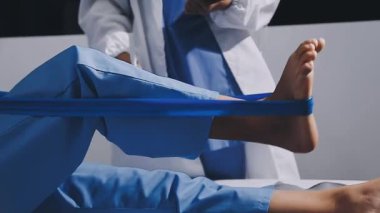 Kadın doktorun steteskop tutarken ve beyaz duvara yaslanırken baş parmağını kaldırırken.