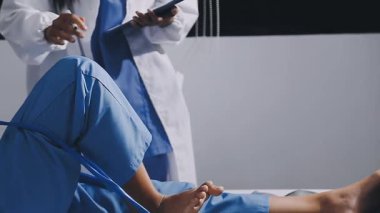 Genç Afro-Amerikan doktor hastanede yatakta yatarken tablet kullanıyor. Sağlık ve Tıp Hizmetleri kavramı