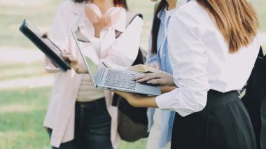 Parkta tablet bilgisayar kullanan genç bir kadın.