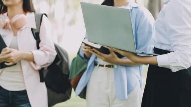 Bir grup genç iş adamı parkta yeni fikirleri tartışıyor.