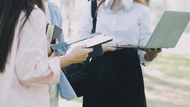 İki genç iş kadını dizüstü bilgisayarda çalışıyor ve bir şey tartışıyorlar.