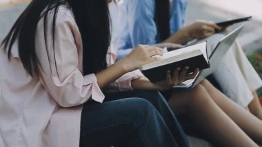 Parkta kitap okuyan genç bir kadın.