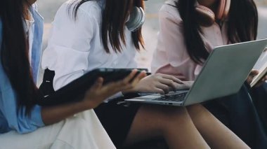 Genç iş adamları şehirde dizüstü bilgisayarla çalışıyorlar.