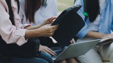 Parkta dizüstü bilgisayar kullanan gençler