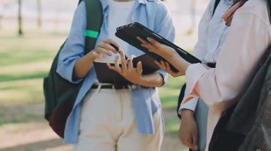 Kampüste okurken tablet bilgisayar kullanan öğrenciler