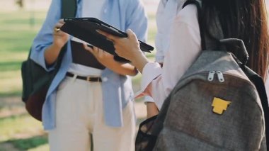 Genç Asyalı kadın şehirde dururken tablet kullanıyor.