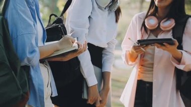 dizüstü bilgisayarı ve tableti olan bir grup genç