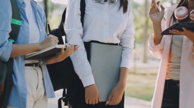 Genç Asyalı kız öğrenciler üniversite kampüsünde okuyor.