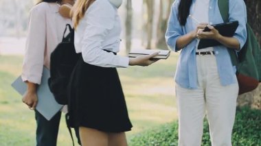 Parkta dizüstü bilgisayarı ve akıllı telefonu olan genç kadınlar