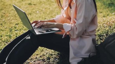 Parkta dizüstü bilgisayarda çalışan bir kız.
