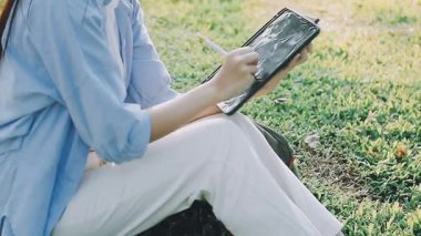 Kadın bahçede tablet bilgisayar kullanıyor