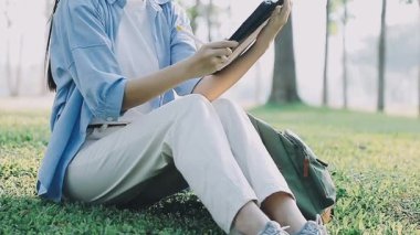 Bankta oturan ve kitap okuyan bir kadın.