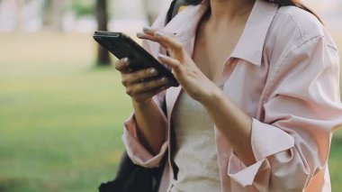 Şehirde akıllı telefon kullanan genç bir kadın..