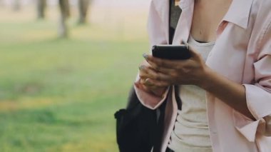 Parkta cep telefonu kullanan bir kadın.