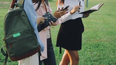 Parkta okuyan ve okuyan genç üniversite öğrencileri.