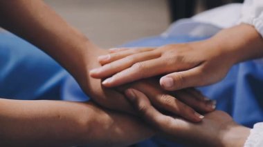 Hastanedeki bir hastayı tutan bir doktorun elini kapatıyoruz.