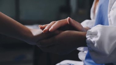 Bir hastanenin arka planında eli olan genç bir kadın.