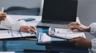 Beyaz takım elbiseli genç bir iş kadını elinde tabletle onu işaret ediyor.