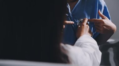 Bir hastayı kontrol etmek için steteskop kullanarak doktor ellerini kapat.
