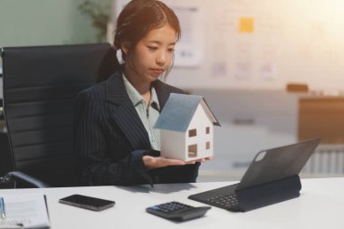 Emlakçılar, konut modellerini müşterilere ayrıntılı bir şekilde anlatma, evler ve satın alma kredileri hakkında bilgi verme ve sunma konularında açıklar. Gayrimenkul ticareti.