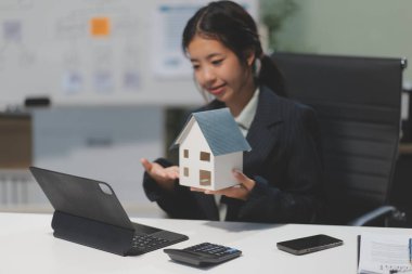 Emlakçılar, konut modellerini müşterilere ayrıntılı bir şekilde anlatma, evler ve satın alma kredileri hakkında bilgi verme ve sunma konularında açıklar. Gayrimenkul ticareti.