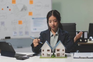 Emlakçılar, konut modellerini müşterilere ayrıntılı bir şekilde anlatma, evler ve satın alma kredileri hakkında bilgi verme ve sunma konularında açıklar. Gayrimenkul ticareti.