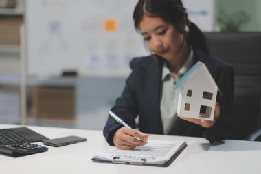 Emlakçılar, konut modellerini müşterilere ayrıntılı bir şekilde anlatma, evler ve satın alma kredileri hakkında bilgi verme ve sunma konularında açıklar. Gayrimenkul ticareti.